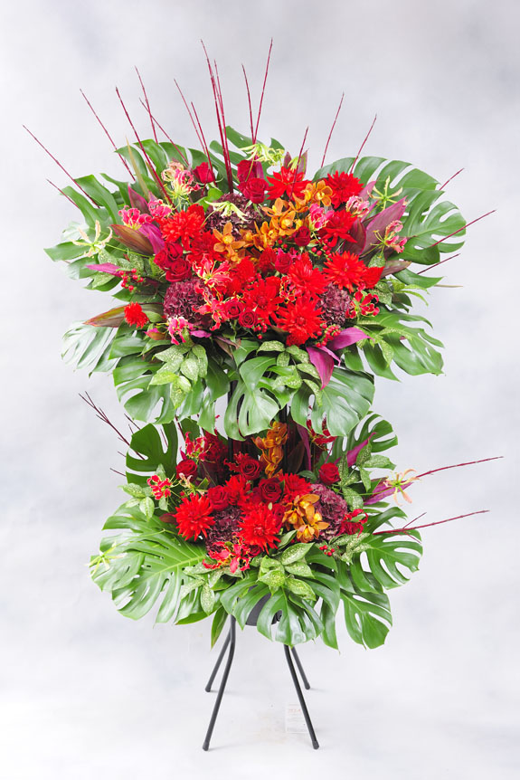 <p>赤系の稀少花材で仕立てたお洒落なスタンド花はいかがですか？</p>