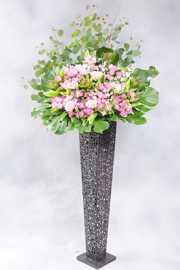 <p>かわいい系のピンクの稀少花材と、スタイリッシュな黒ブリキのコントラストがお洒落なスタンド花です。</p>