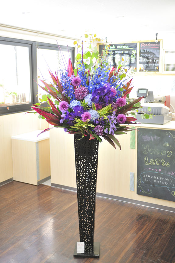 <p>紫＆青色の稀少花材で仕立てるスタイリッシュな黒ブリキ一段スタンド花です。</p>