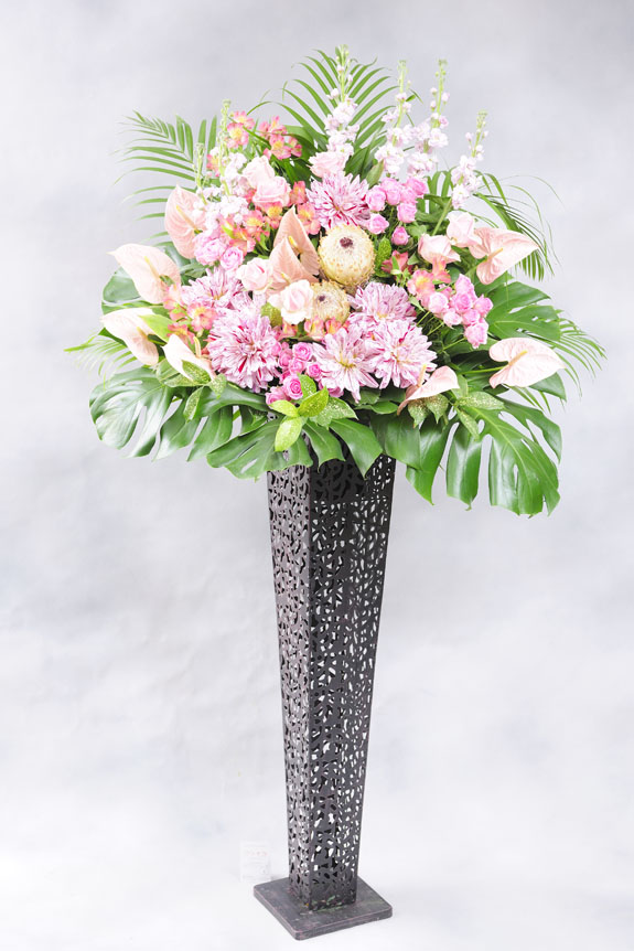 <p>ピンク系の稀少花材と黒ブリキスタンドでスタイリッシュにお仕立てするスタンド花。</p>