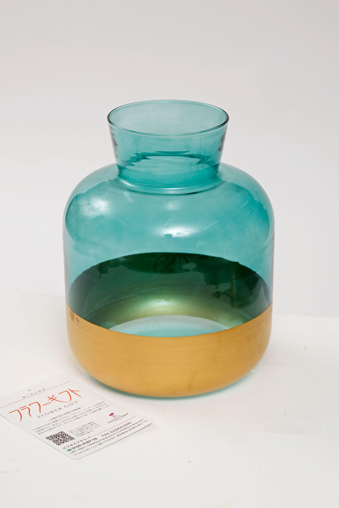 <p>花瓶はガラス製で、青とゴールドのシンプルでおしゃれなデザインが特徴です。</p>