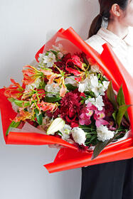 抱きかかえられる大きなめでたい紅白の花束16,500円(税込)