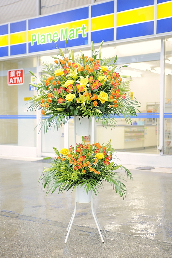 温かみ溢れる黄色とオレンジを中心とした暖色系2色仕立てのスタンド花二段タイプです。