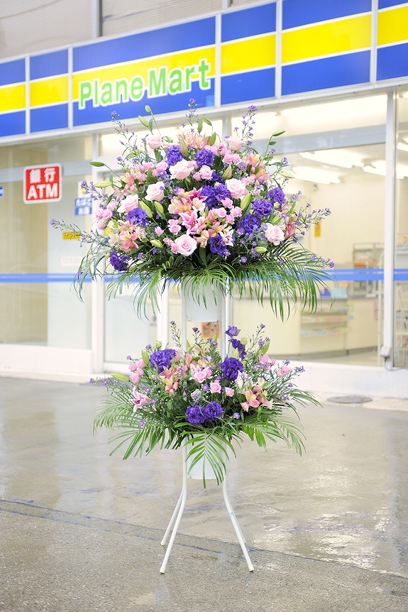 華やかな装飾に重厚感を加えたピンクとパープル系2色仕立てのスタンド花二段タイプです。