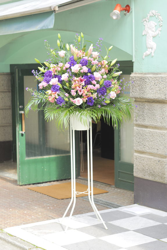 華やかな装飾に重厚感を加えたピンクとパープル系2色仕立てのスタンド花です。