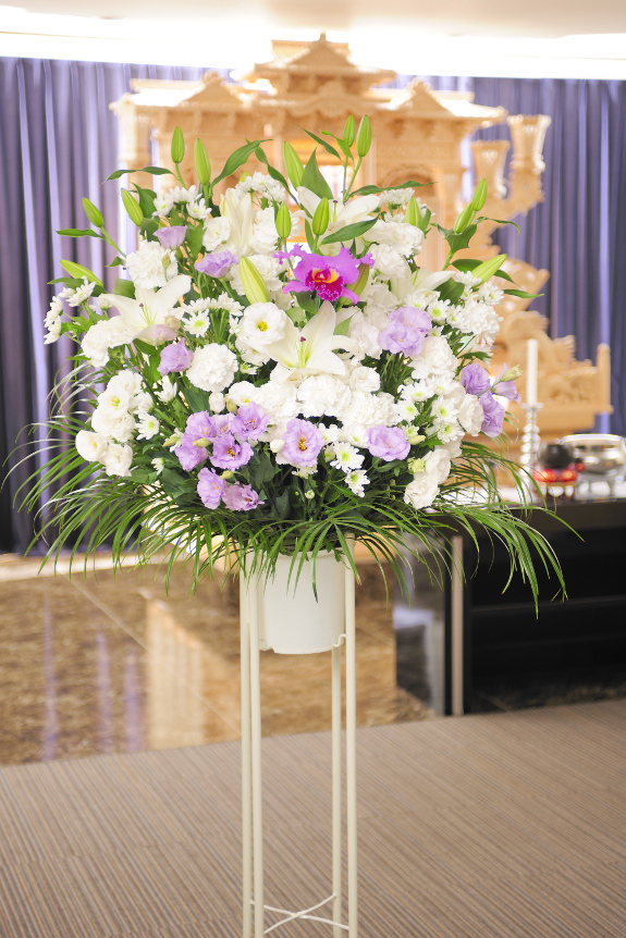 標準1.5万円コースの洋花タイプの供花スタンド花で、白・紫系の２色指定です。