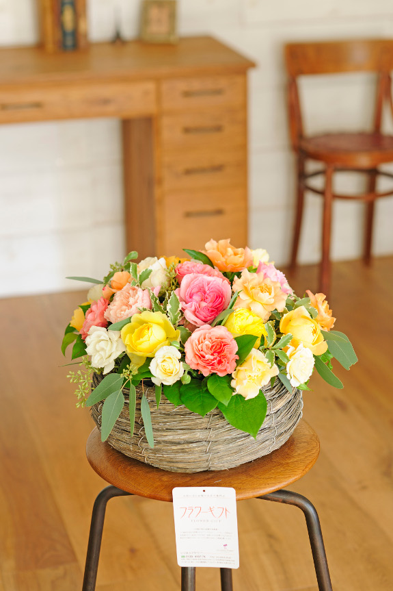 丸型のバスケットタイプの容器に入れてお届けする薔薇（バラ）はアットホームで可愛らしいサイズです。玄関先やテーブルなどにさりげなく設置する事で、空間を華やかなにしてくれるアレンジメントフラワーです。