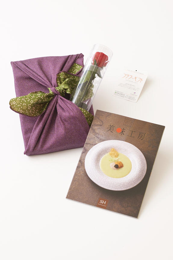<p>贈り物（ステムローズとカタログ）を風呂敷（紫/グリーン）で華やかに彩ります。</p>