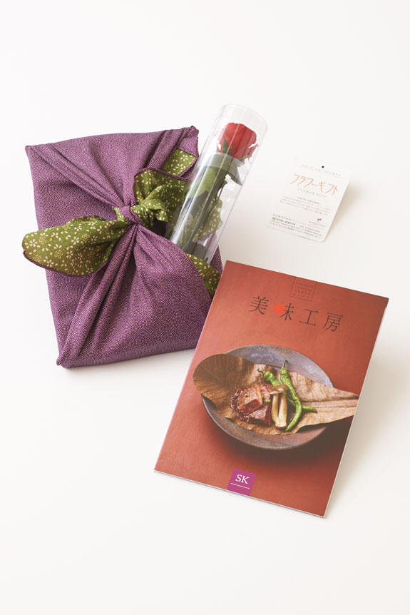 <p>贈り物（ステムローズとカタログ）を風呂敷（紫/グリーン）で華やかに彩ります。</p>