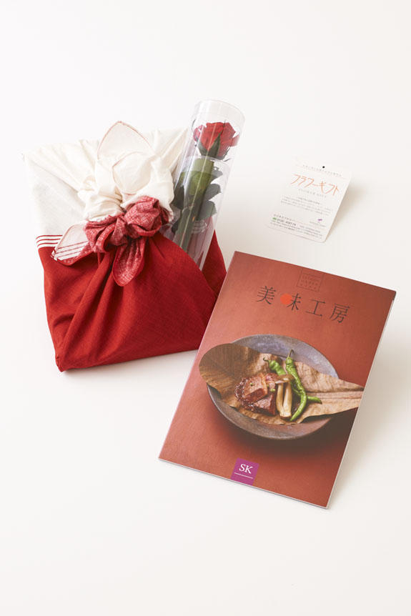 <p>贈り物（ステムローズとカタログ）を風呂敷の「華包み」で華やかに彩ります。</p>