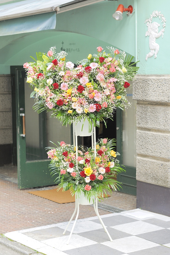 愛嬌たっぷりのお祝いにかわいらしいハート仕立てのスタンド花二段タイプです。