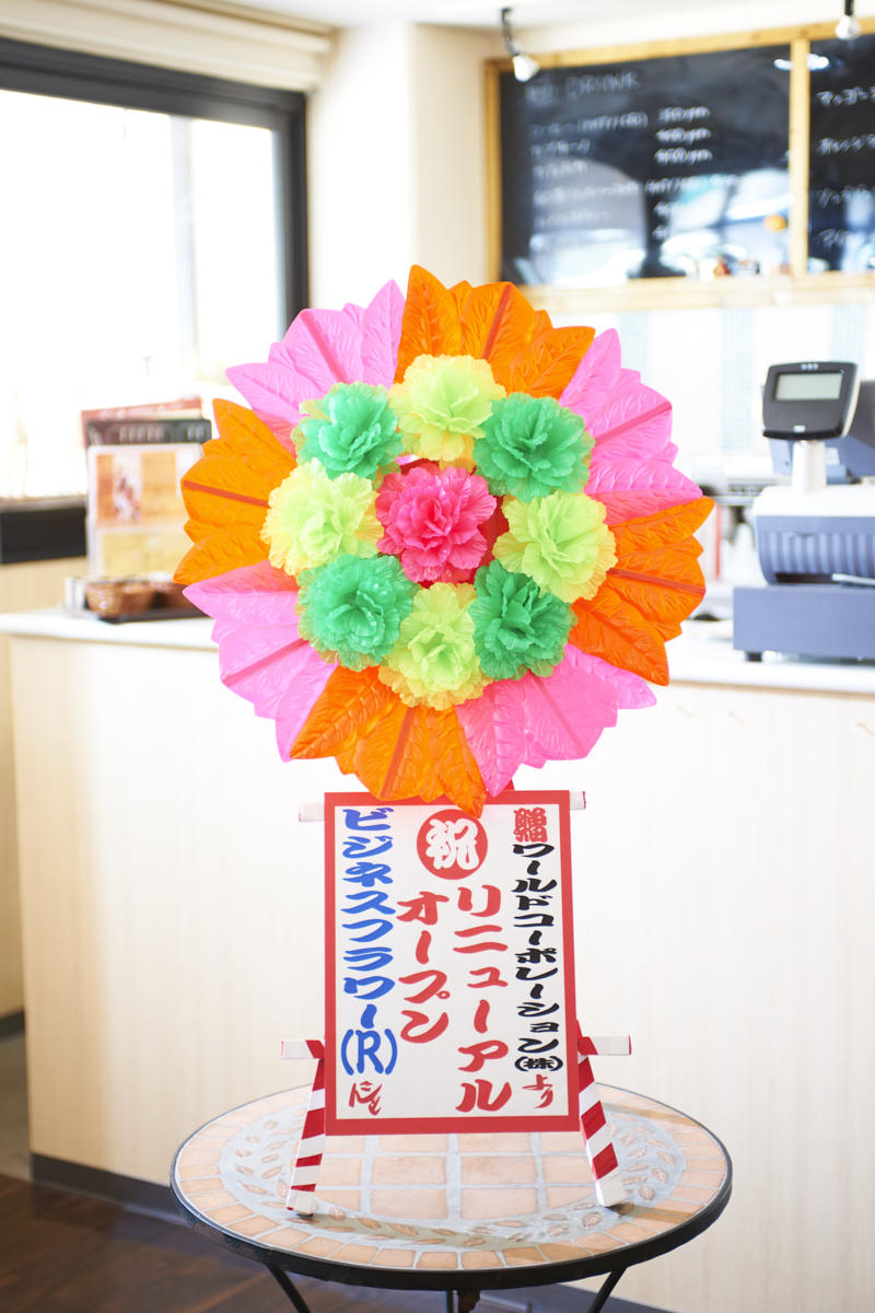 インパクト抜群の造花ミニ花輪（赤・ピンク）は新装開店祝いにぴったりです。