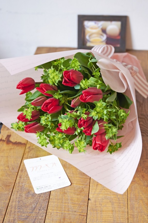 春らしいチューリップとラッピング＆リボンの組み合わせが印象的な赤色の花束・ブーケです。