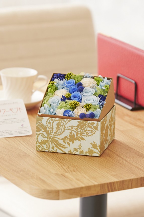 蓋を開けると、落ち着きのある青・グリーン系のお花が顔を出す、デザイナーのセンスが溢れる作品です。