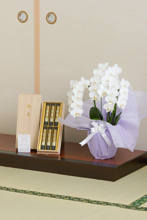 ご自宅宛てサイズとして人気のあるミディ（ミニ）サイズのお供え用胡蝶蘭（コチョウラン）とお線香を一緒にお届けするお得なセット商品です。
