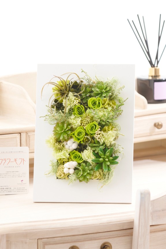 爽やかなホワイトのウッドフレームに、多肉植物のプリザーブドフラワーをデザインした商品です。