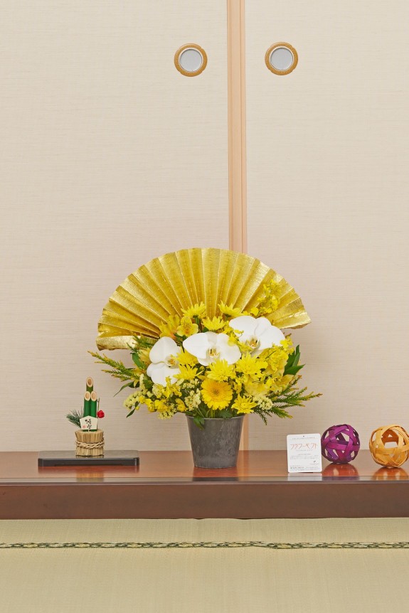 大きな黄金の扇飾りが目に留まる、新春飾りに相応しい豪華な黄系のアレンジメントフラワーです。