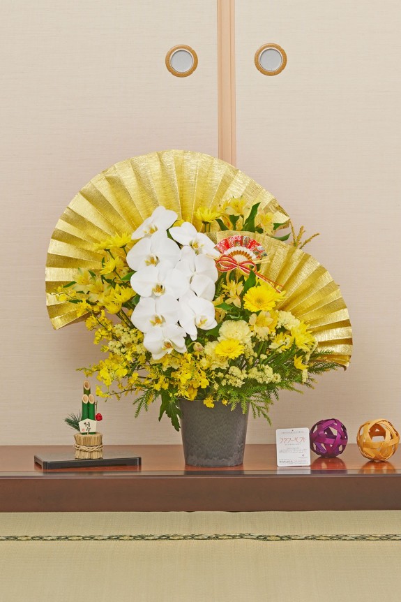 大きな黄金の扇飾りが目に留まる、新春飾りに相応しい豪華な黄系のアレンジメントフラワーです。