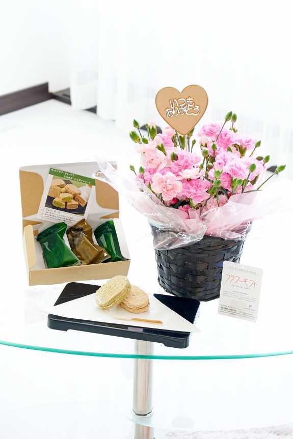 母の日の贈り物の定番カーネーションに、「いつもありがとう」の3D立体ピックを挿した鉢植えと、京都の茶匠きよ泉の宇治抹茶とほうじ茶で仕立てたダクワーズをセットにしたフラワーギフト用の商品です。