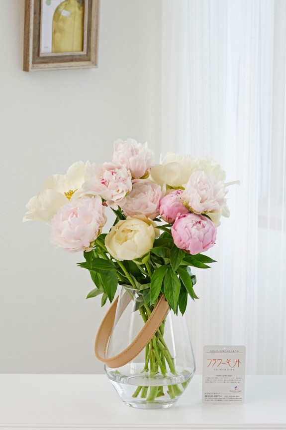 ５月頃の季節花である芍薬（シャクヤク）の花束にレザーホルダーが付いたクリアガラスのお洒落な花瓶（フラワーベース）がセットになった商品です。