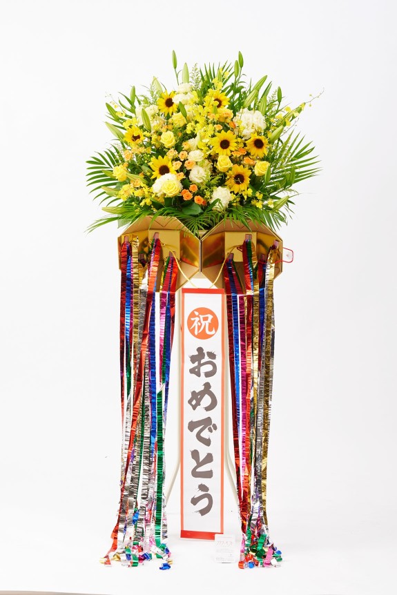 お祝いのシーンを盛り上げる存在感のあるくす玉が付いた、思わず目に留まる派手なスタンド花です。