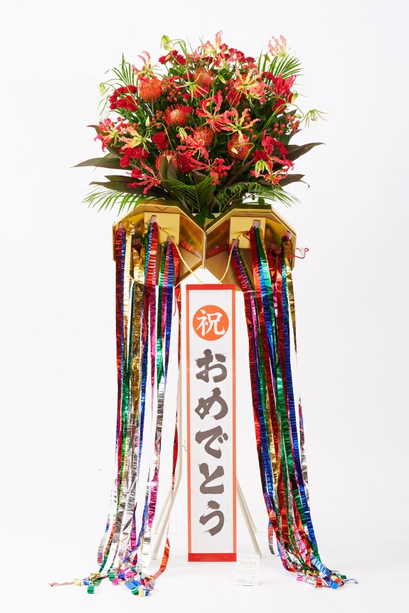 お祝いのシーンを盛り上げる存在感のあるくす玉が付いた、思わず目に留まる派手なスタンド花です。