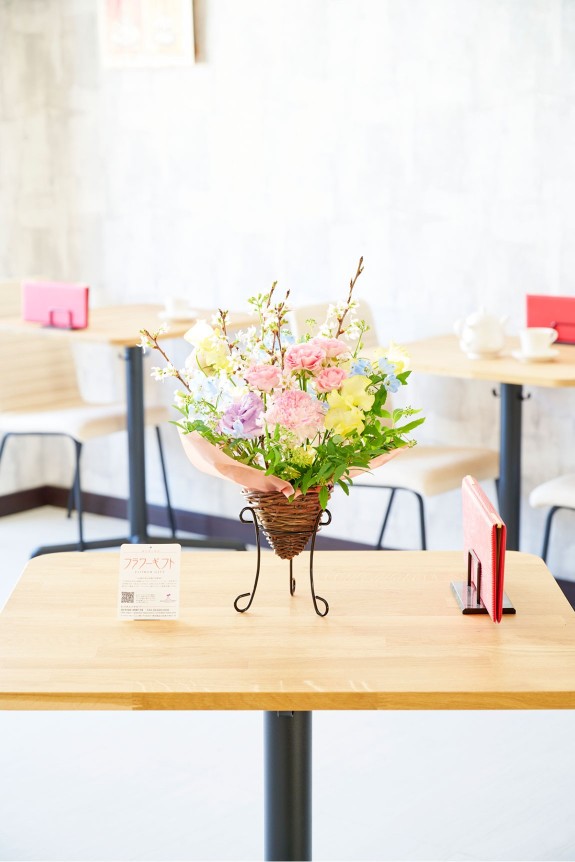 <p>木網のバスケットに金属製の脚、スタンド花を彷彿させるシルエットが特徴のおしゃれなフラワーアレンジメントです。</p>