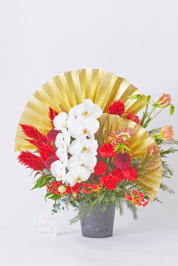 大きな黄金の扇飾りと純白の胡蝶蘭が目に留まる、大切なお祝いに相応しい豪華な赤色系のアレンジメントフラワーです。