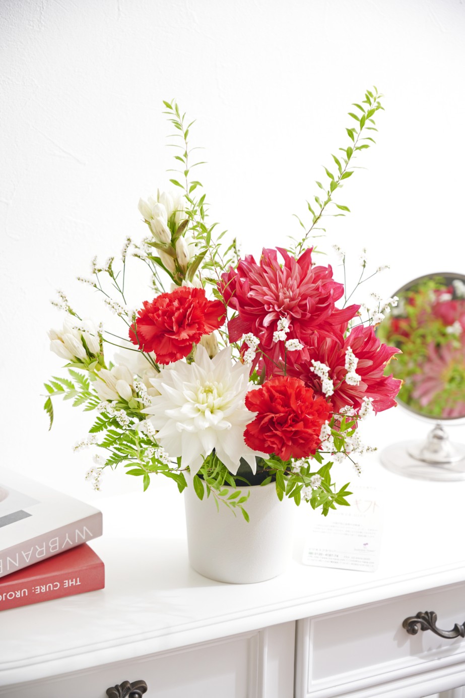 鮮やかな赤と清らかな白の花々を組み合わせた、華やかな紅白カラーのダリアアレンジメント。