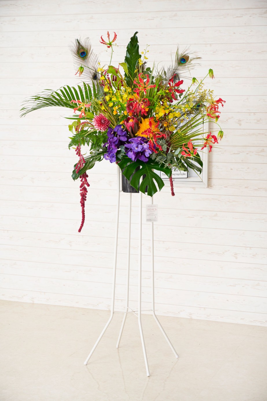 縁起物の孔雀の羽を使用したデザイナー仕立てのアートなスタンド花です。